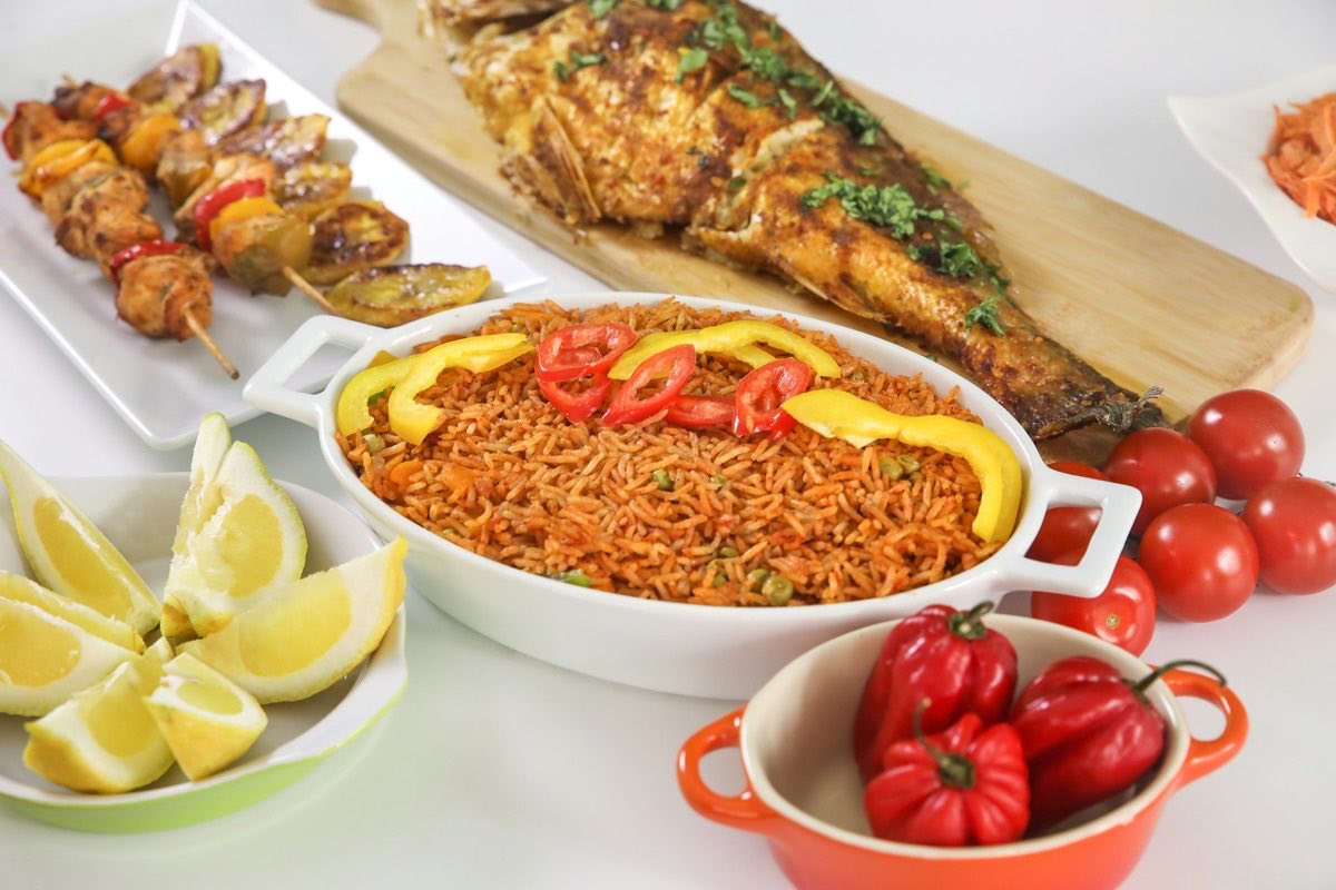 Jollof rice with grilled fish, kebabs and peppers